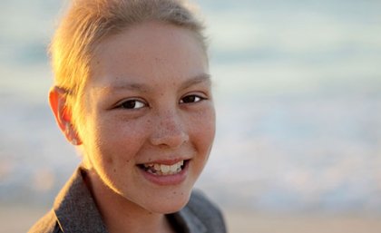 Headshot of a girl on a beach.